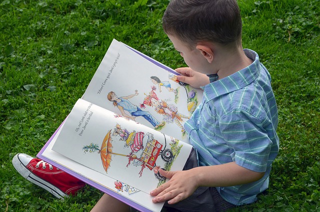 boy reading picture book outside