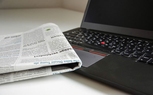 newspaper and laptop