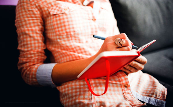 woman writing in book