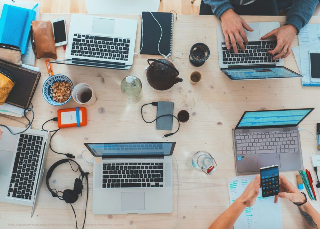 several laptop computers and cell phones on table