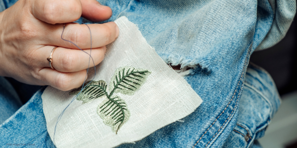 person embroidering jeans