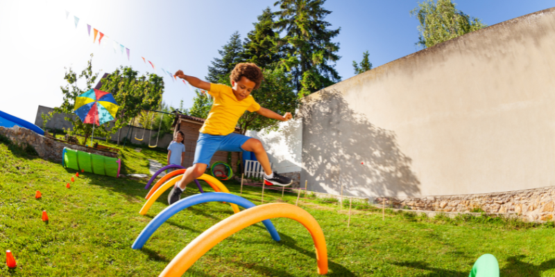 child jumping over obstacles