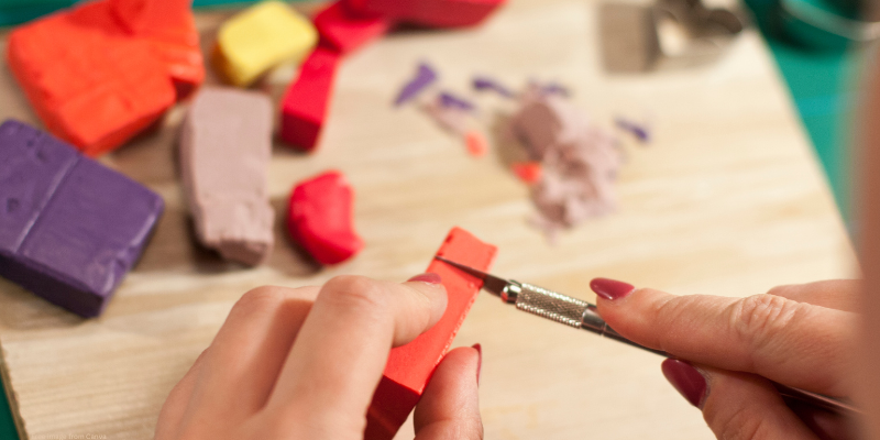 person cutting clay