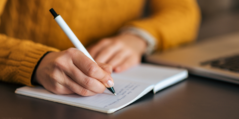 person writing in notebook