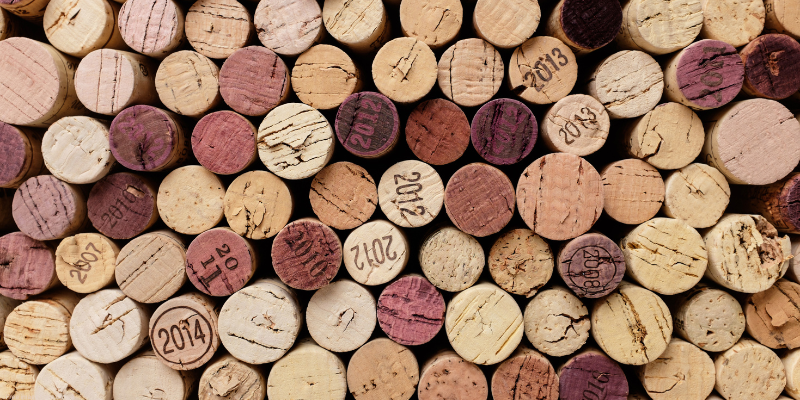 A collection of stacked wine corks with various colors and years printed on them.