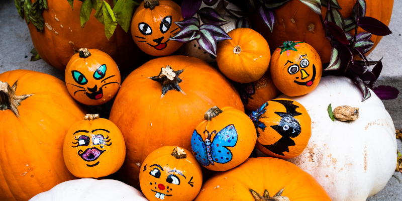 a variety of different shaped pumpkins with painted faces and designs