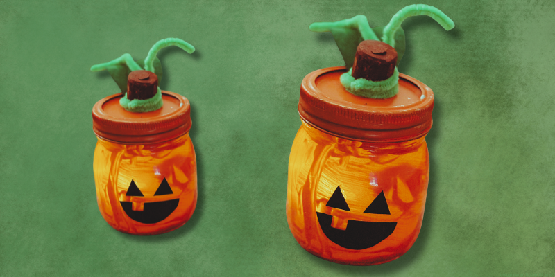 green background with two small orange glowing jars with jack o lantern faces
