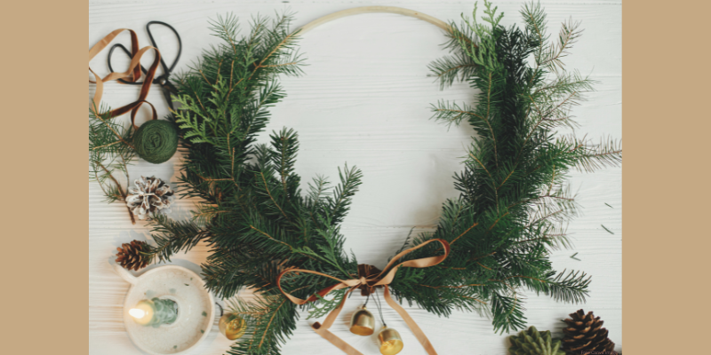 large wreath on a wooden hoop with pine branches and ribbon on it