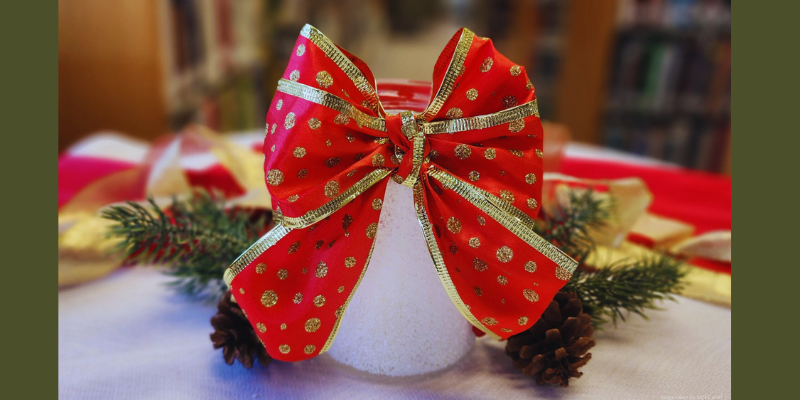 white mason jar with red bow and gold detail sitting on a table