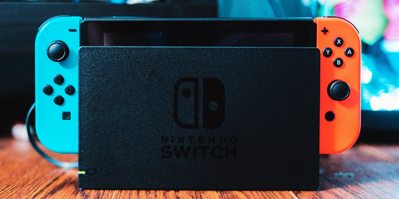 image of nintendo switch console plugged in with controllers attached