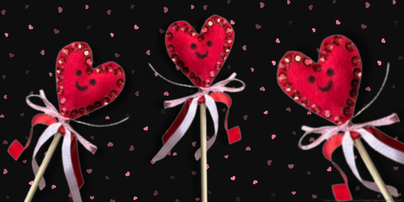 A black background with mini colored hearts, featuring three felted hearts attached to wooden dowels with ribbon and sequins.