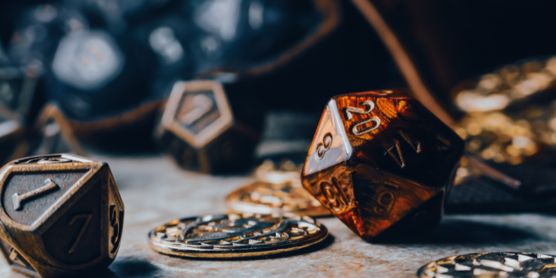 close up of d20 dice and an old bag with coins