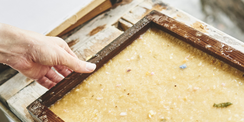close up of a hand with a paper making screen