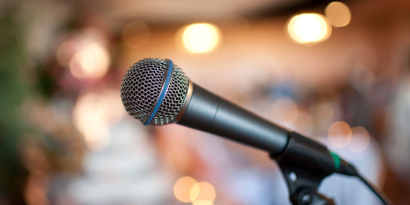 Close-up of a microphone with blurred warm lights in the background