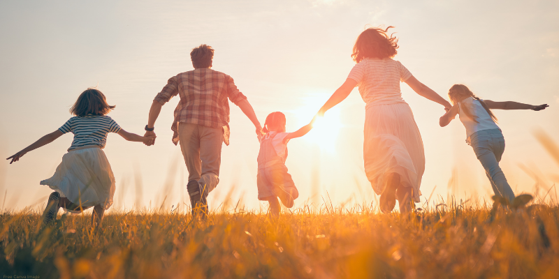 family holding hands with a sunset in the background
