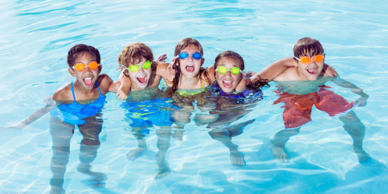 group of children in a pool wearing goggles