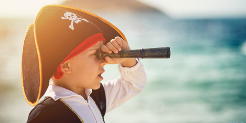 child dressed as a pirate looking through a spy glass