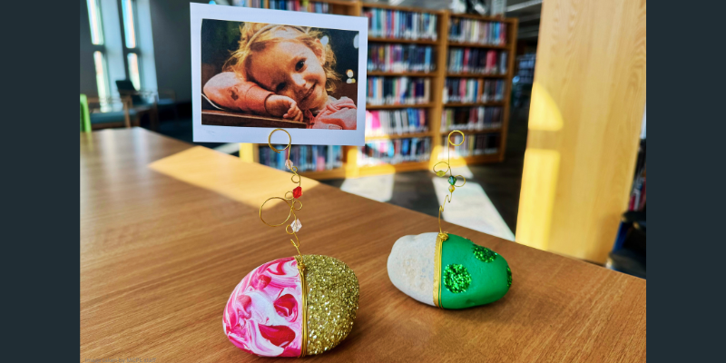 image of two painted rocks with glitter and wire holding a picture