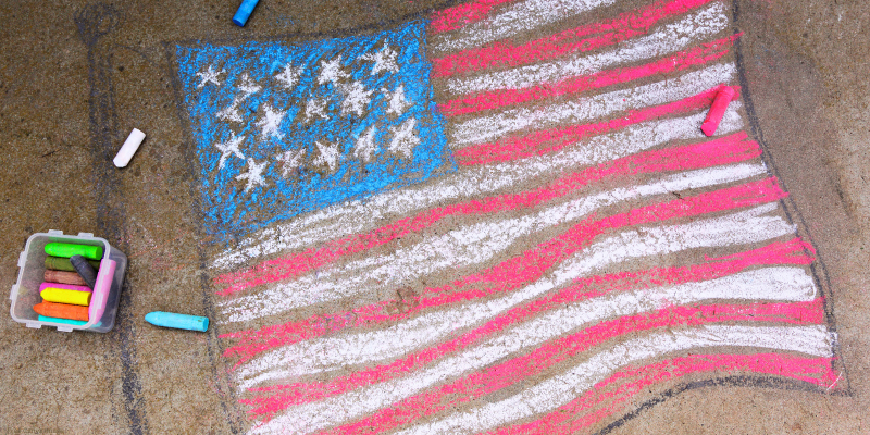 chalk drawing of an american flag with chalk nearby