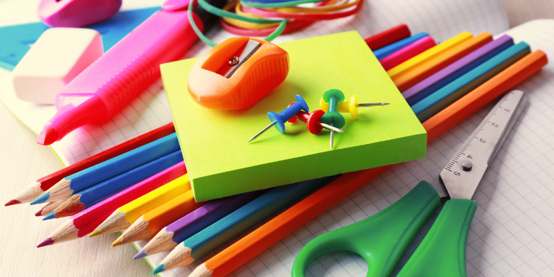 variety of school supplies such as colored pencils, scissors, highlighters, and erasers