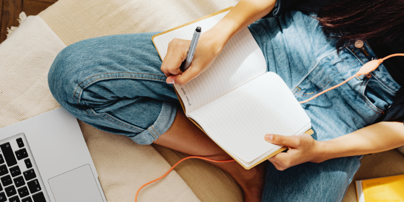 young adult writing in notebook