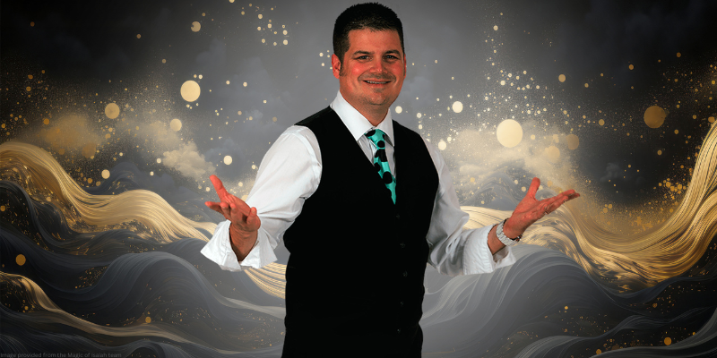 black background with gold swirls and magician isaiah in the middle with his arms open and smiling