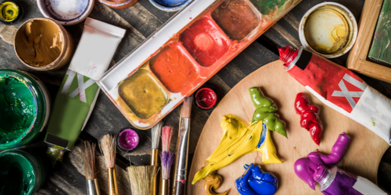 paint tray, brushes, and paint on a table